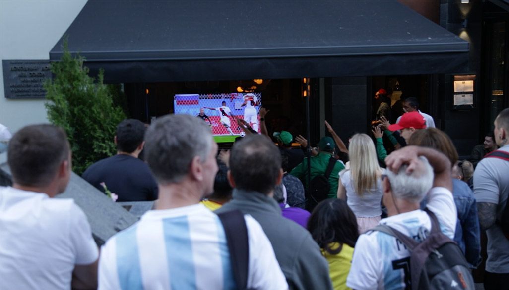 サッカー放送中。飲食店の中のモニターにも外から人だかりが