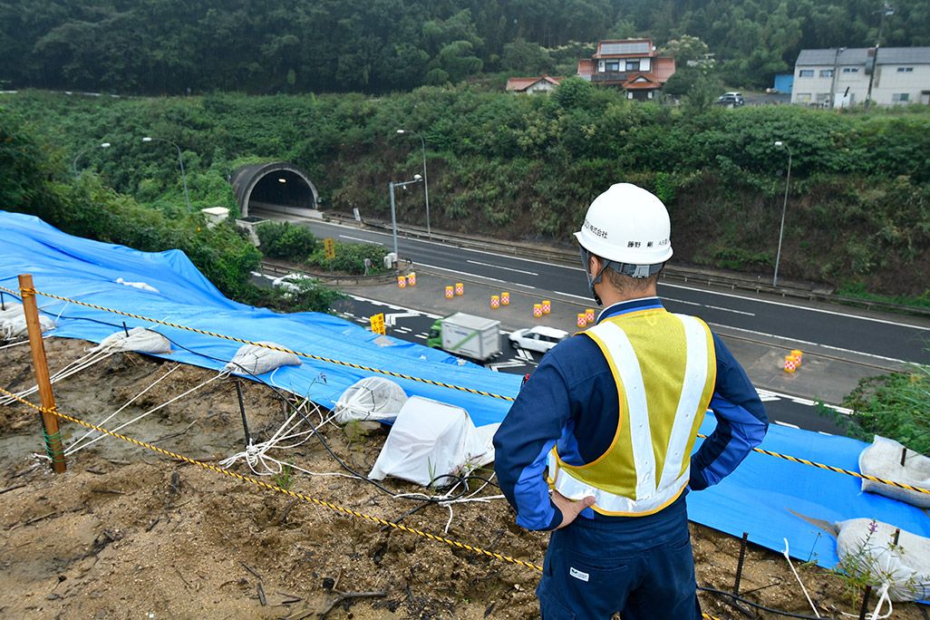 志和トンネルの復旧作業を見つめる作業着姿の男性