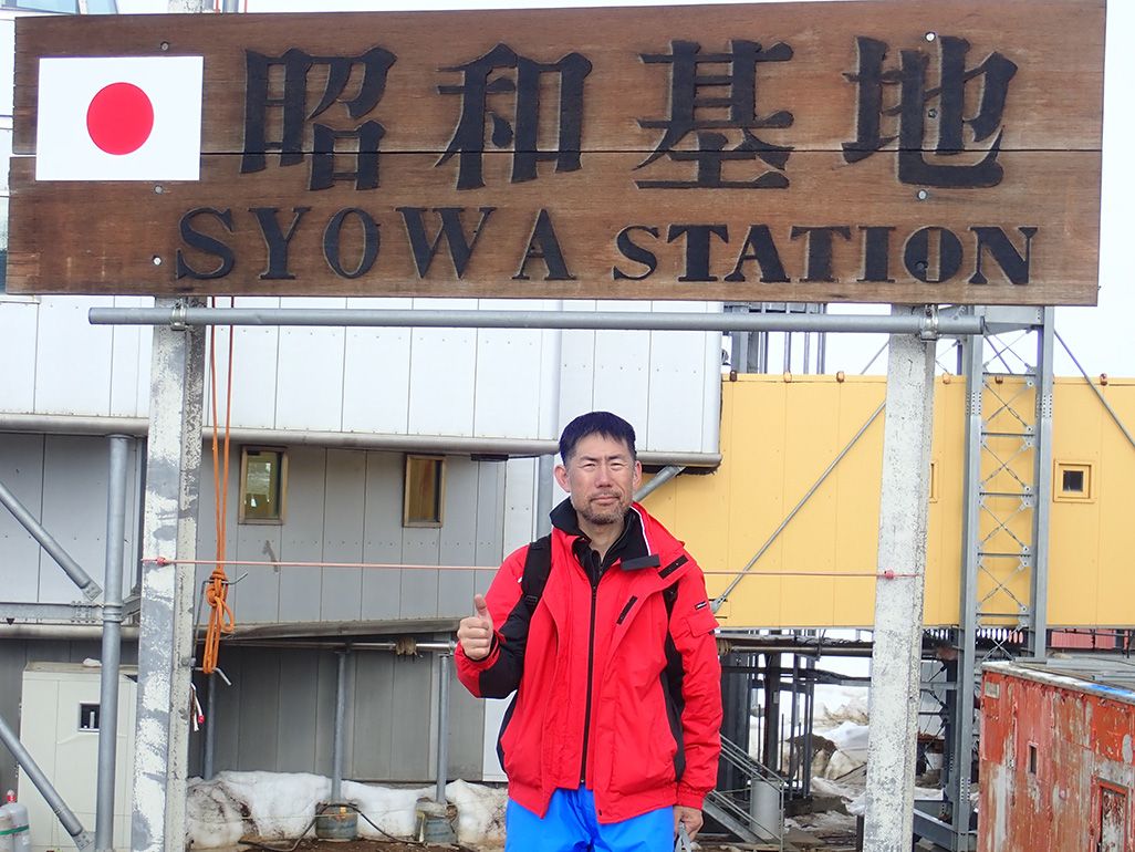 南極・昭和基地の看板の前に立つ第59次南極観測隊の齋藤