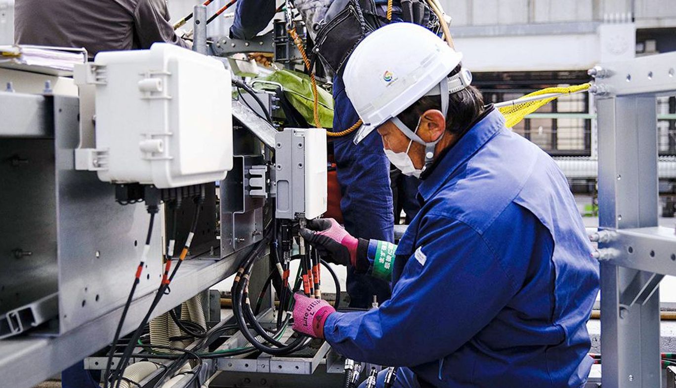 KDDIの基地局で作業する人