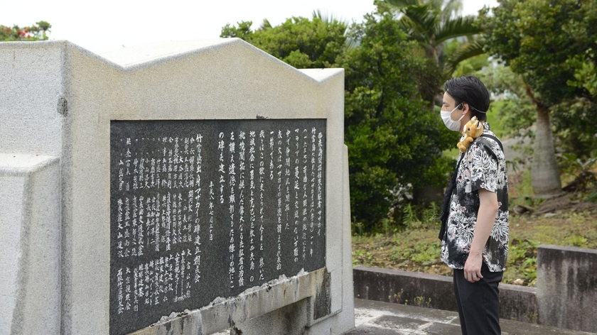 KDDIの高精度GNSS測位を活用した自動音声ガイドを装着しながら沖縄県 西表島 大富地区の街巡りツアーを楽しむ人