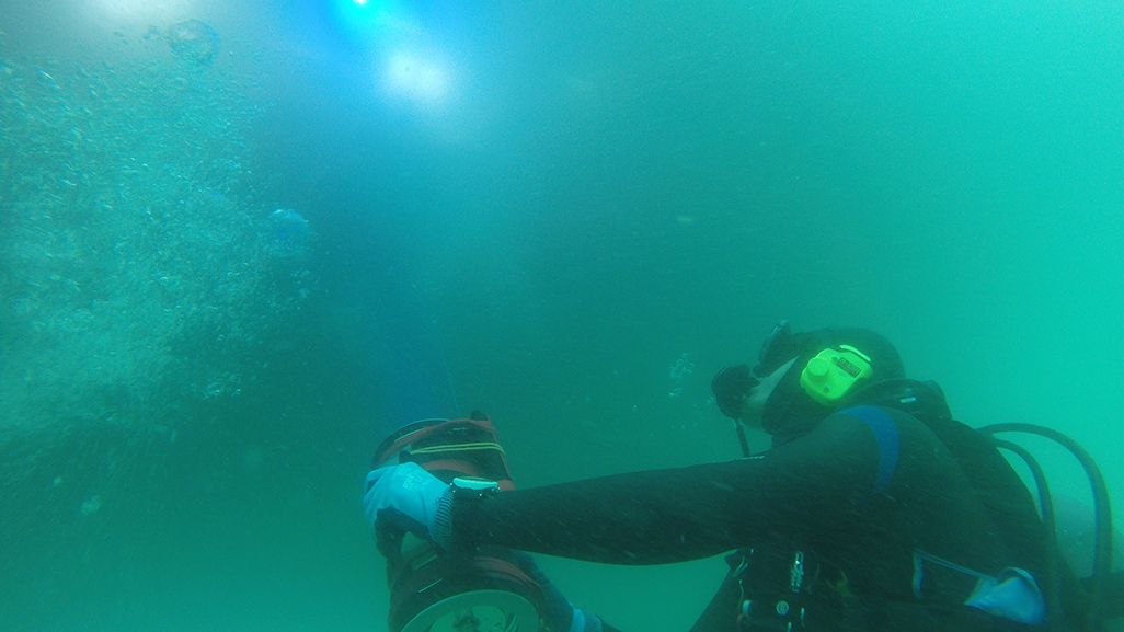 陸側の装置の光を水中で受けるダイバー