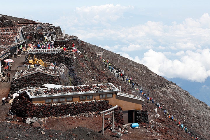 登山者が連なる富士山頂付近。2013年に世界遺産に登録された影響か、外国人の姿も少なくない