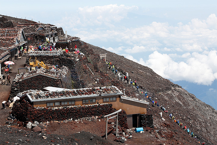 登山者が連なる富士山頂付近。2013年に世界遺産に登録された影響か、外国人の姿も少なくない