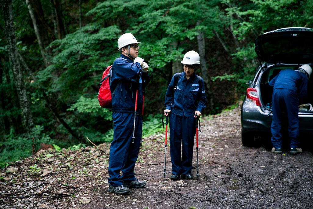 登山靴に履き替え、両手にストックを持ち、登山の準備を整える。安全対策のためヘルメットも欠かせない