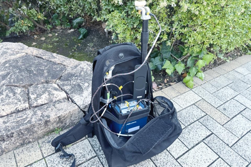 KDDIの電波をキャッチできるアンテナを背負い、タブレットでモニタリングを行う